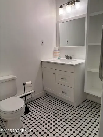 a bathroom with a toilet a sink and a mirror
