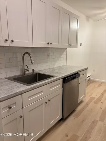 a kitchen with stainless steel appliances granite countertop white cabinets a refrigerator and a stove