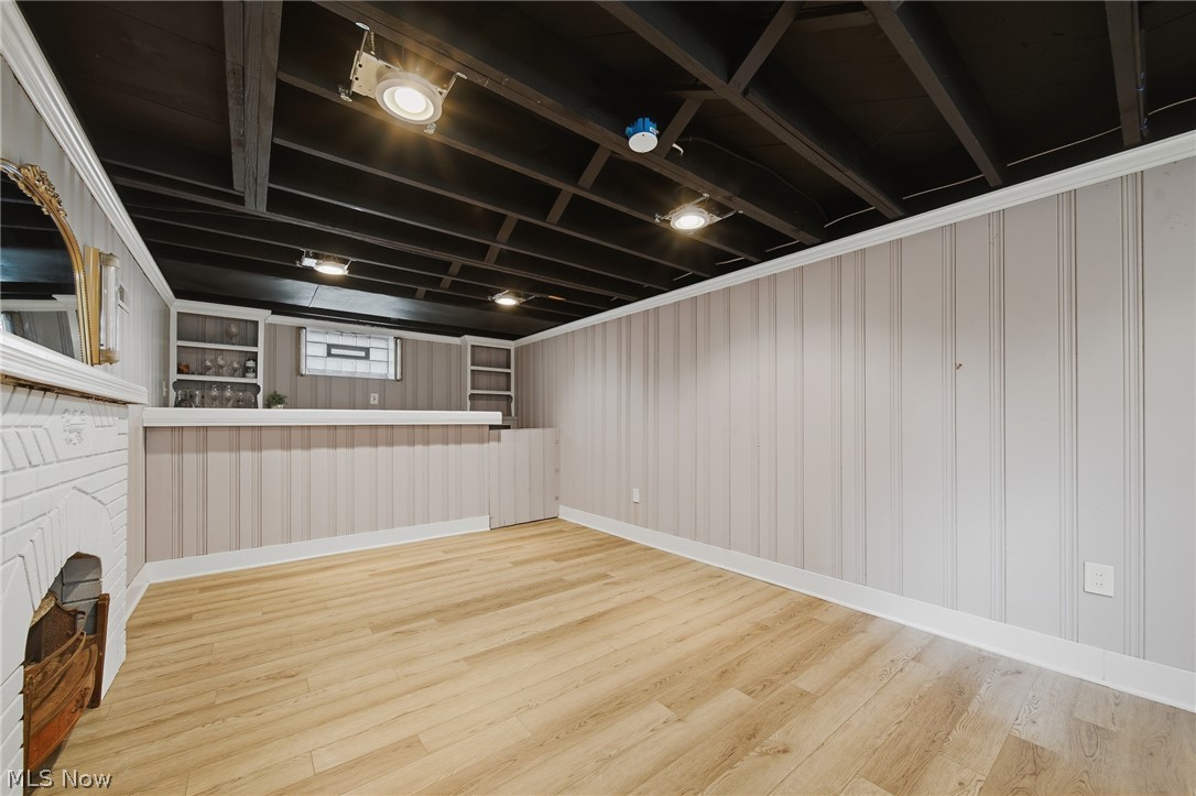 2231 Brockway Road University Heights, OH 44118 - Photo 31 of 46 Recreation room featuring wood-finish flooring, a built-in wetbar with shelving, a white brick fireplace, wainscoting, and exposed beam ceilings with recessed lighting