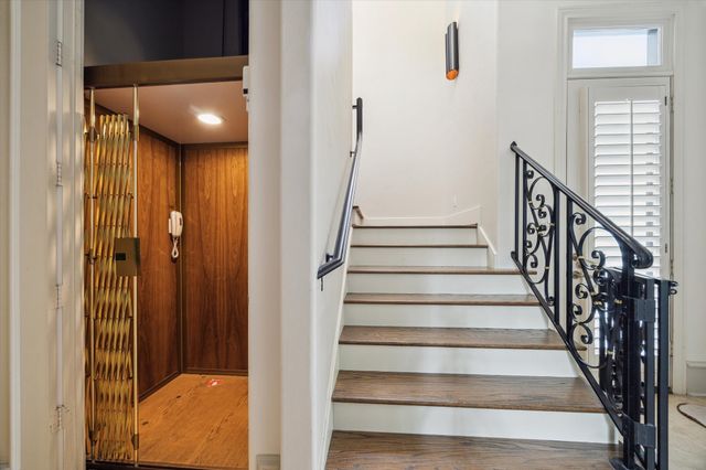 a view of a hallway with wooden floor and stairs