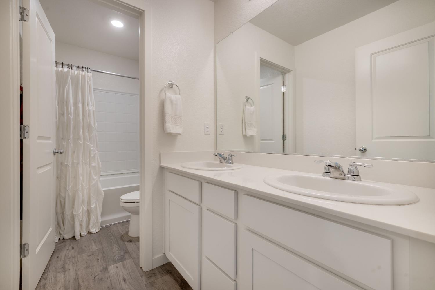 4041 Trailblazer Loop Roseville, CA 95747 - Photo 15 of 23 a bathroom with a double vanity sink mirror and toilet
