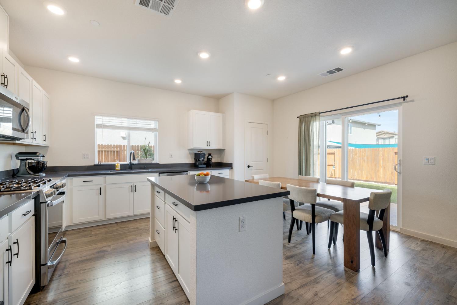 4041 Trailblazer Loop Roseville, CA 95747 - Photo 8 of 23 a kitchen with a sink dining table chairs and wooden floor
