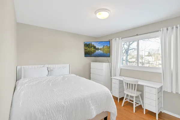 a bedroom with a bed and a large window