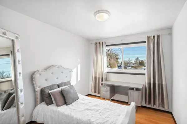 a bedroom with a bed and a large window