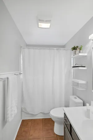 a bathroom with a sink a toilet and shower curtain