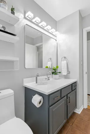 a bathroom with a granite countertop sink a toilet and a mirror