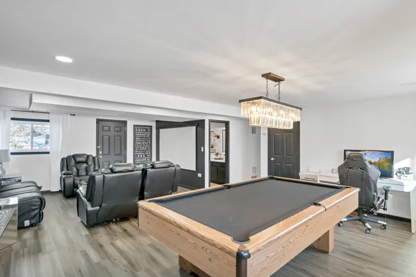 a living room with furniture chandelier and wooden floor