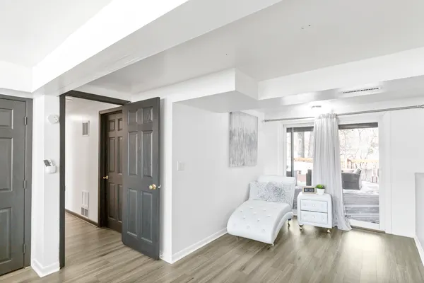a spacious bedroom with a bed and wooden floor