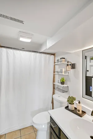 a bathroom with a sink a toilet and shower curtain