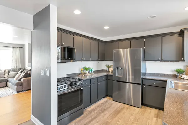 a kitchen with stainless steel appliances granite countertop a refrigerator stove and microwave