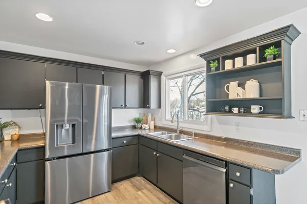 a kitchen with stainless steel appliances granite countertop a refrigerator and a sink
