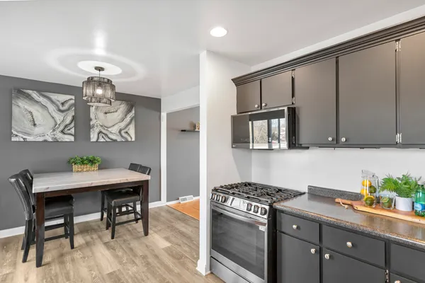 a kitchen with stainless steel appliances granite countertop a stove a sink dishwasher and cabinets with wooden floor