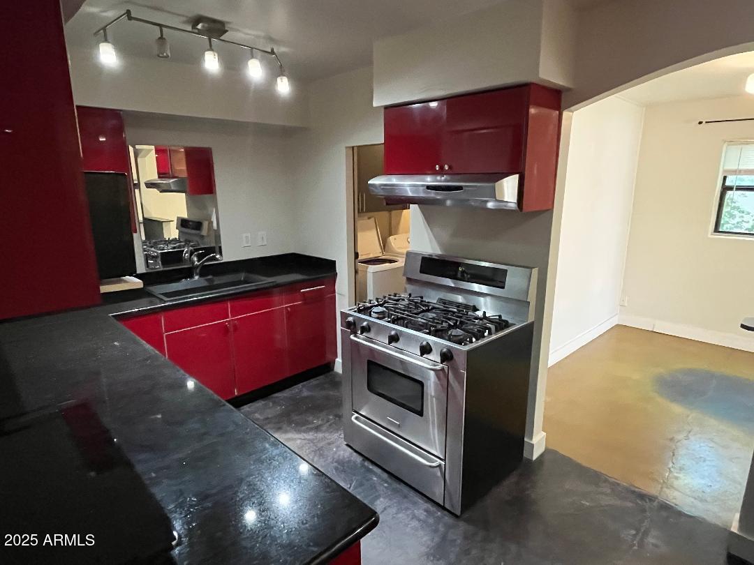 1006 East Weldon Avenue Phoenix, AZ 85014 - Photo 7 of 34 a kitchen with stainless steel appliances granite countertop a stove a sink and a microwave
