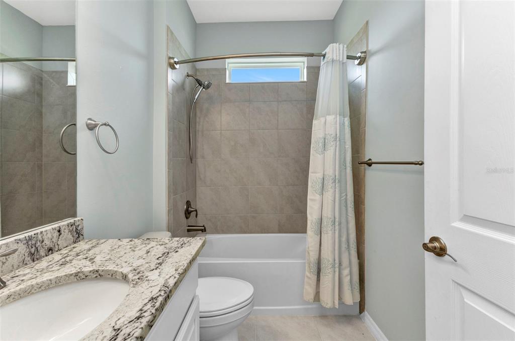 7028 North Plum Tree Punta Gorda, FL 33955 - Photo 11 of 57 a bathroom with a granite countertop bathtub shower sink vanity and toilet