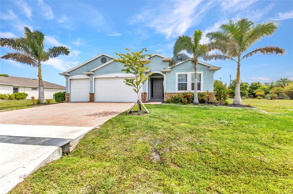 7028 North Plum Tree Punta Gorda, FL 33955 - Photo 42 of 57 a front view of a house with a garden and trees