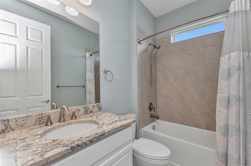 7028 North Plum Tree Punta Gorda, FL 33955 - Photo 10 of 57 a bathroom with a granite countertop toilet sink and shower