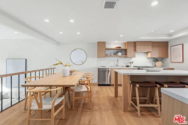 a view of a dining room with furniture a rug and wooden floor
