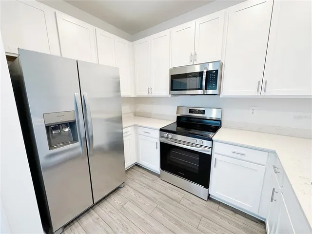 a kitchen with a refrigerator stove and microwave