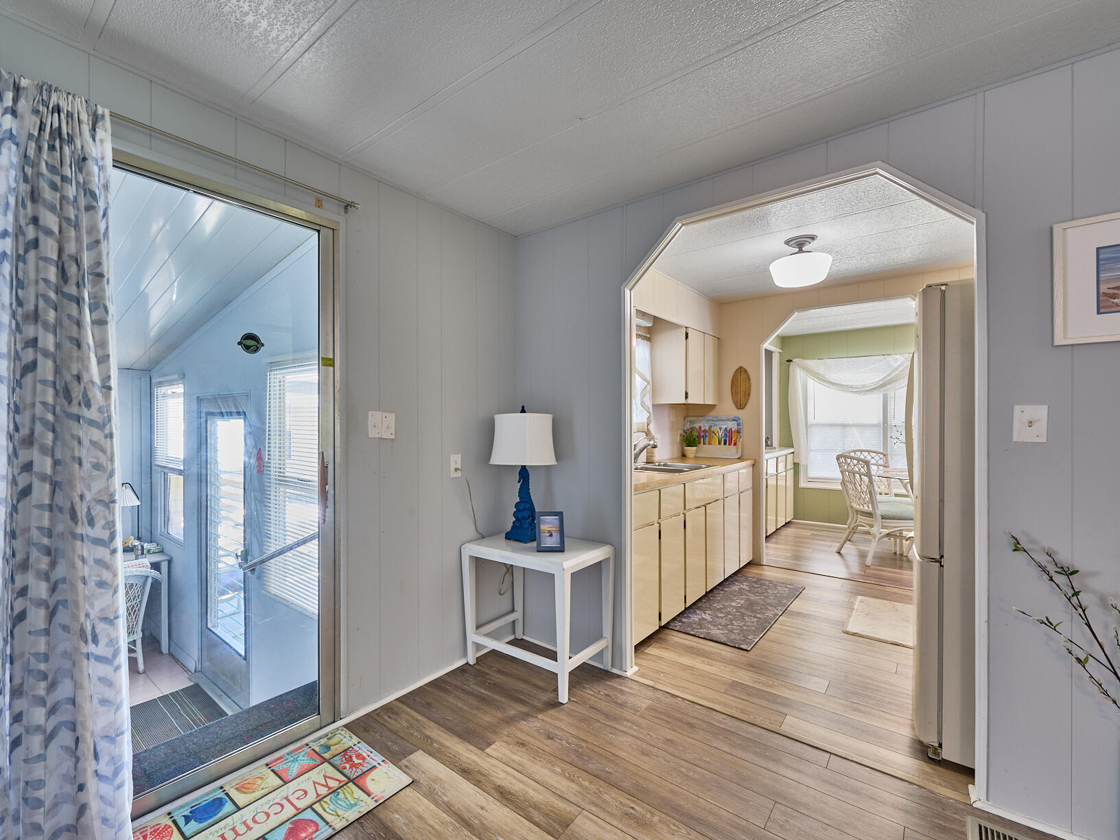 6977 Southeast Delegate Street Hobe Sound, FL 33455 - Photo 11 of 60 a open kitchen with white cabinets and glass door