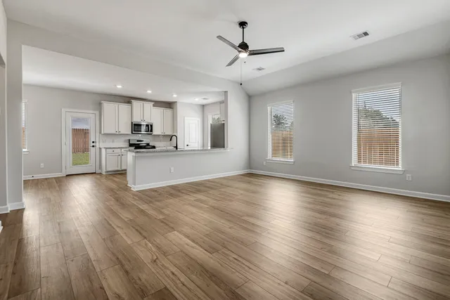 a view of a kitchen with stove and wooden floor