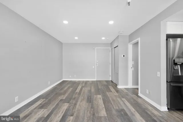a view of a room with wooden floor and a hallway