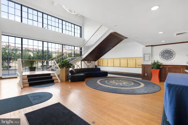 a living room with furniture a rug and a floor to ceiling window