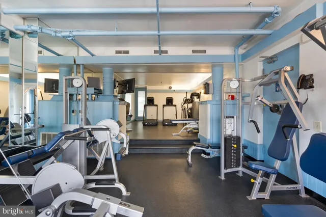 a large white kitchen with wooden floor and a large window