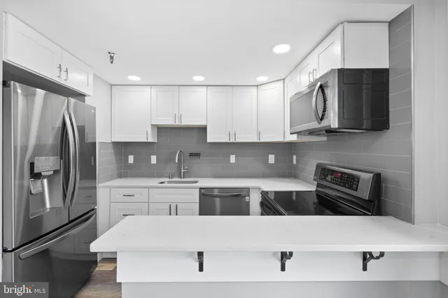 a kitchen with stainless steel appliances a refrigerator a stove a microwave and cabinets