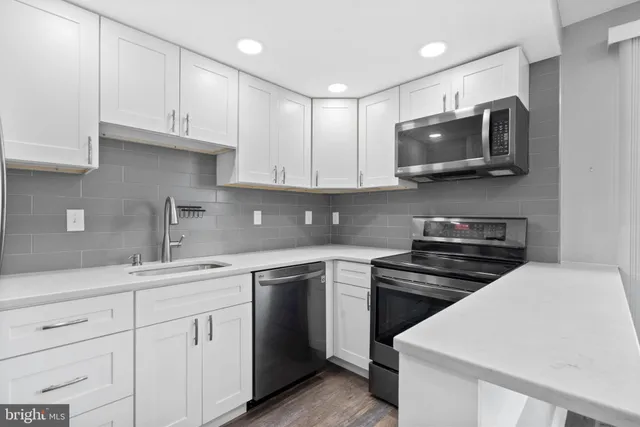 a kitchen with white cabinets and stainless steel appliances