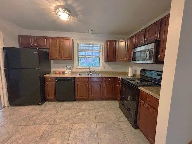 a kitchen with stainless steel appliances granite countertop a stove a sink dishwasher a refrigerator and a microwave