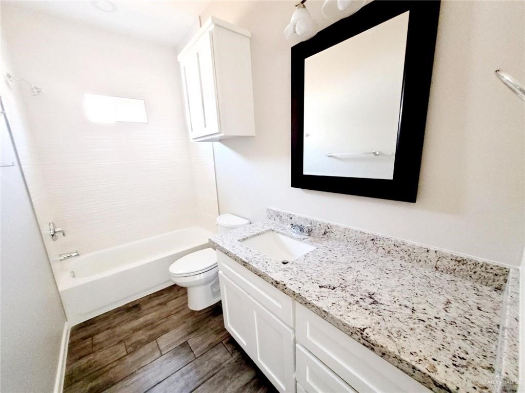 5801 Sandpiper Avenue, Unit 3 McAllen, TX 78573 - Photo 11 of 17 Full bathroom featuring bathing tub / shower combination, vanity, and dark wood finished floors