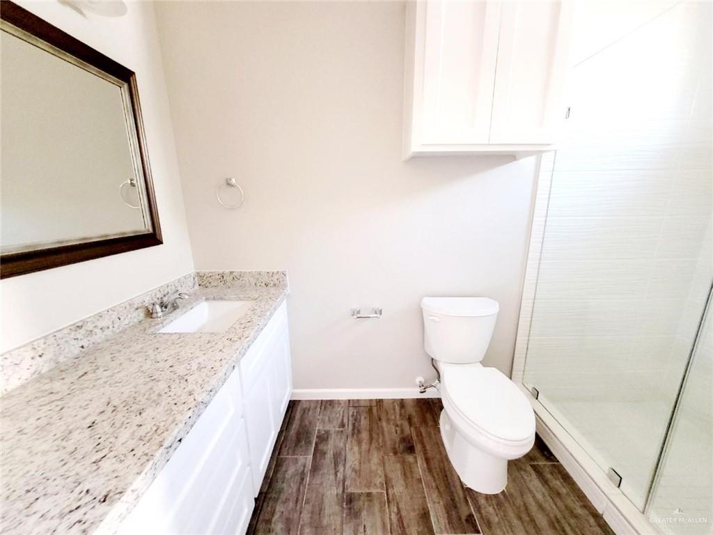 5801 Sandpiper Avenue, Unit 3 McAllen, TX 78573 - Photo 12 of 17 Bathroom with vanity, dark wood-style floors, and a stall shower