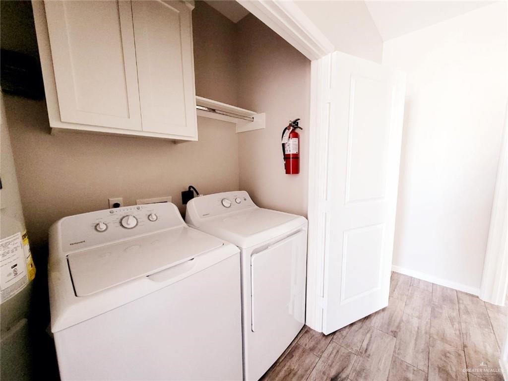 5801 Sandpiper Avenue, Unit 3 McAllen, TX 78573 - Photo 14 of 17 Laundry room with light wood-style floors, separate washer and dryer, cabinet space, and water heater