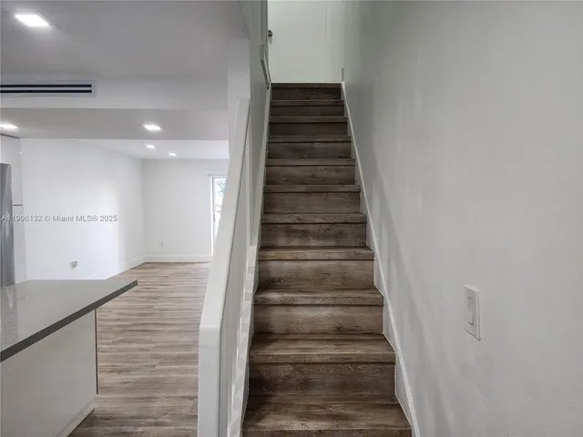 a view of a hallway with wooden floor and entryway