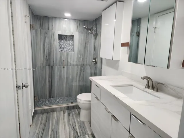a bathroom with a sink a toilet and shower