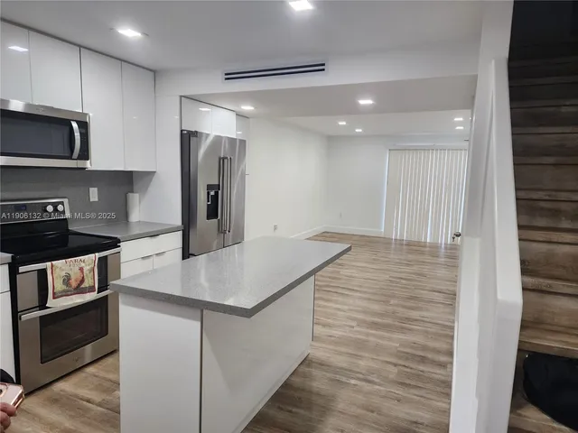 a kitchen with a refrigerator and a sink