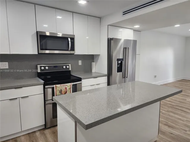 a kitchen with stainless steel appliances a microwave a sink and a refrigerator