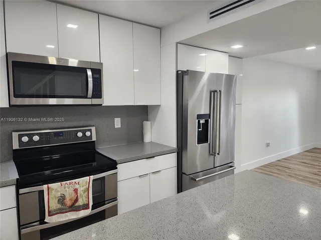 a kitchen with stainless steel appliances granite countertop a stove microwave and refrigerator
