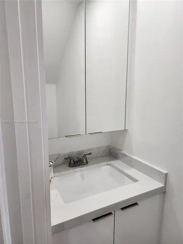 a white toilet sitting next to a white wall