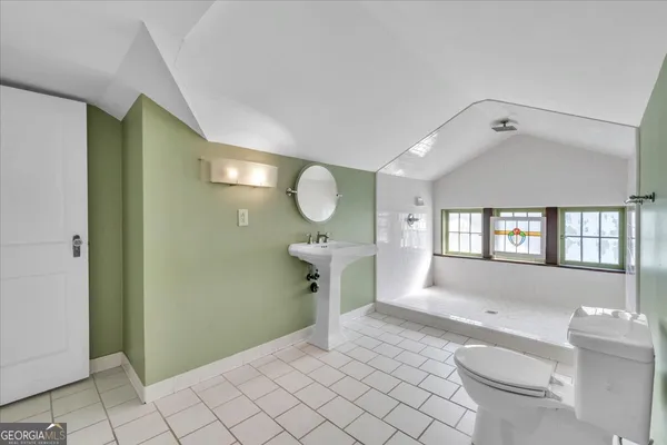 a bathroom with a sink a toilet and a mirror