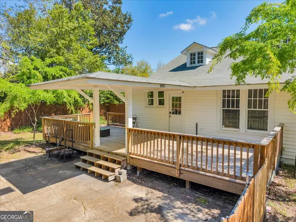 a view of a deck with a floor to ceiling window next to a yard