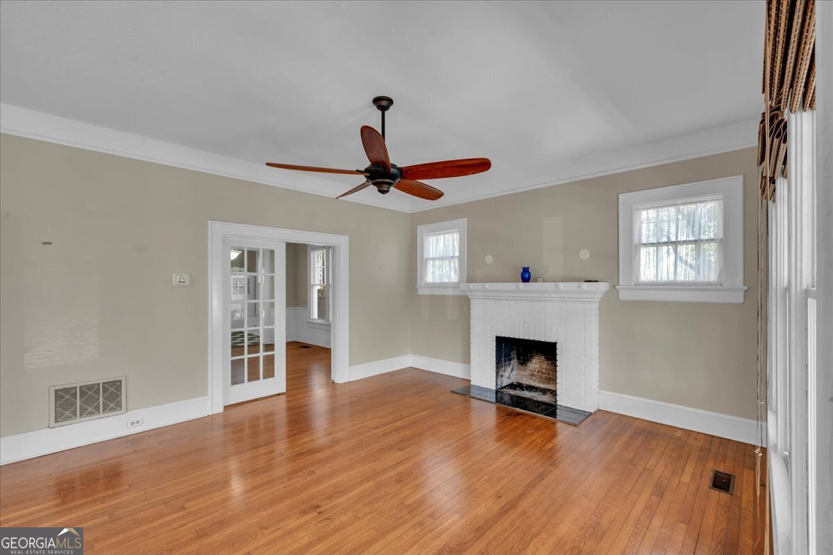 218 West Drive Dublin, GA 31021 - Photo 4 of 49 a view of an empty room with wooden floor fireplace and a window