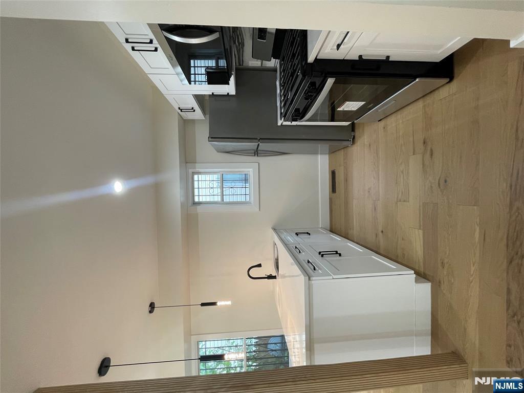 399 18th Avenue, Unit 1 Newark, NJ 07108 - Photo 3 of 9 a large white kitchen with stainless steel appliances granite countertop a stove and a sink