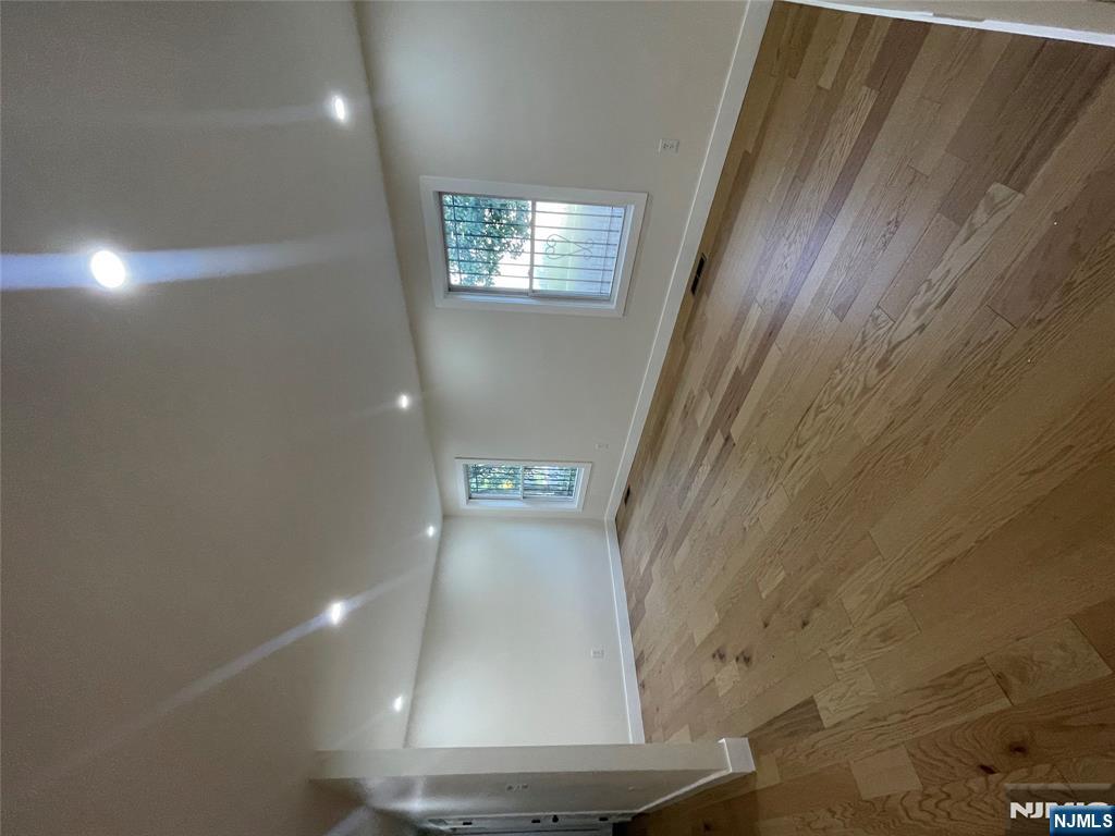 399 18th Avenue, Unit 1 Newark, NJ 07108 - Photo 6 of 9 an empty room with wooden floor and windows