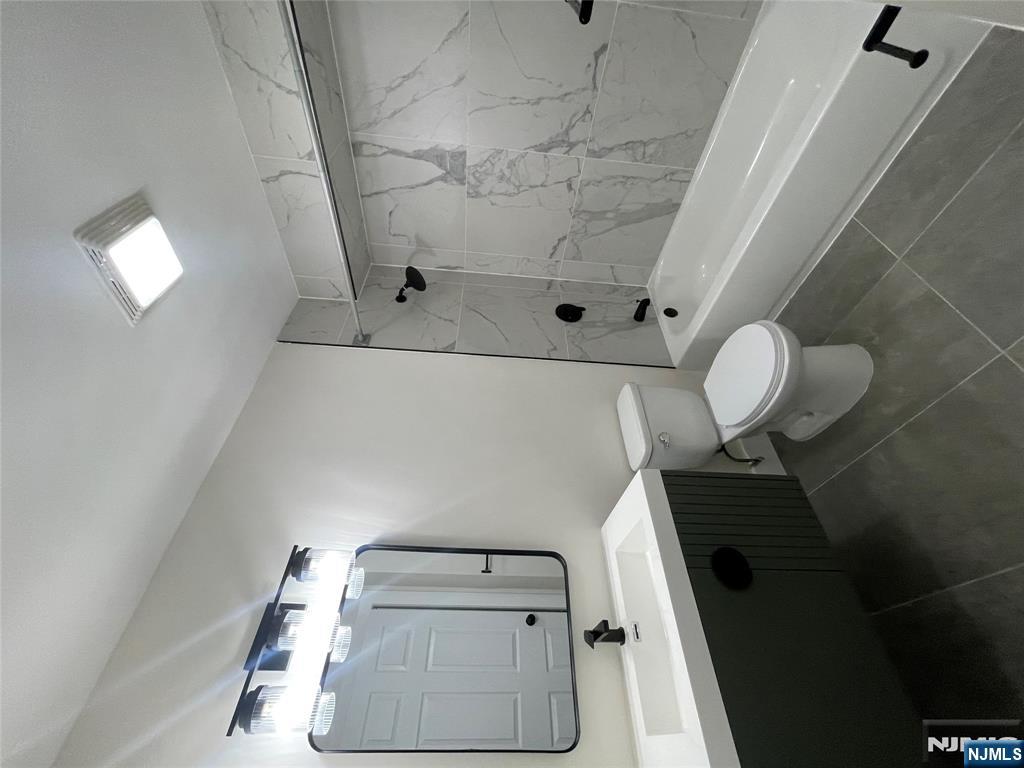 399 18th Avenue, Unit 1 Newark, NJ 07108 - Photo 9 of 9 a bathroom with a toilet sink and mirror