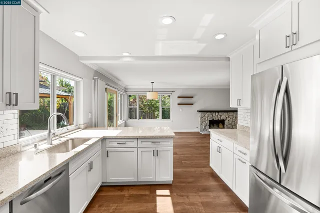 a kitchen with a stove a sink and wooden floor