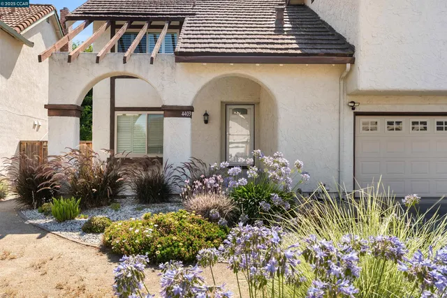 a front view of a house with a lot of flower plants