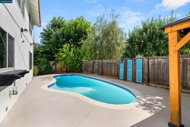 a backyard with wooden fence and large trees