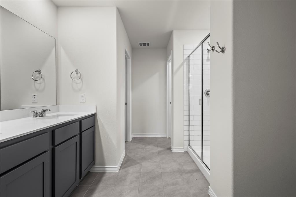 812 Indigo Road Princeton, TX 75407 - Photo 17 of 25 a spacious bathroom with a double vanity sink mirror and shower