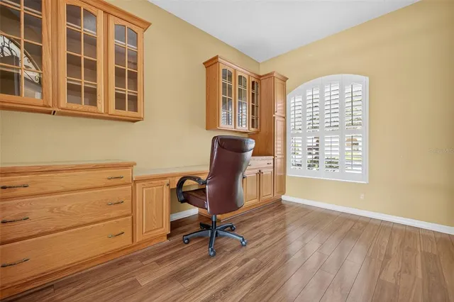 a view of a workspace with furniture and a window
